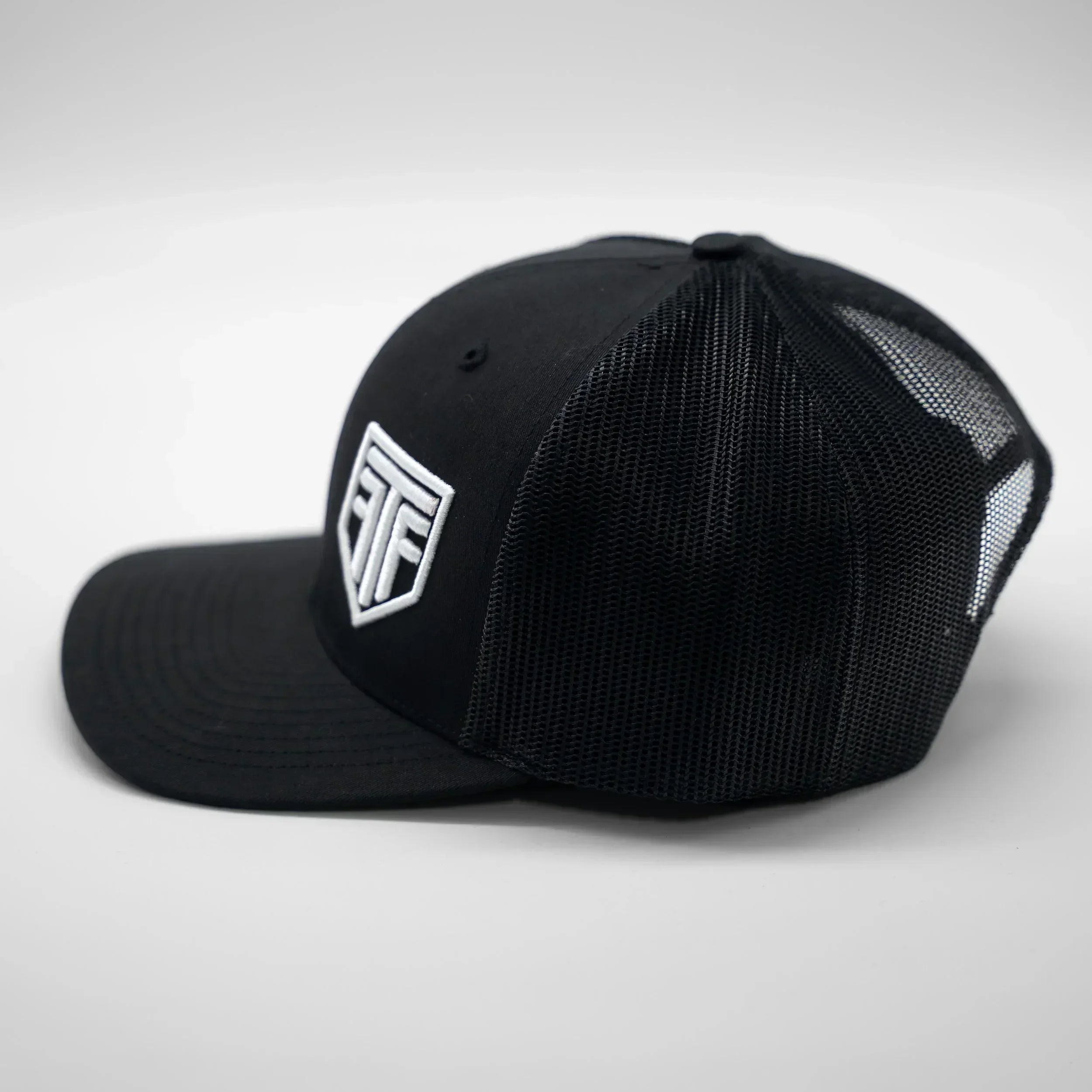 Black cap with a logo on a light gray background
