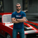 Man in a blue t-shirt standing in front of a red and white car