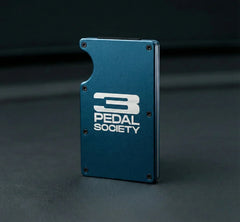 Blue metal bracket with '3 Pedal Society' logo on a dark background