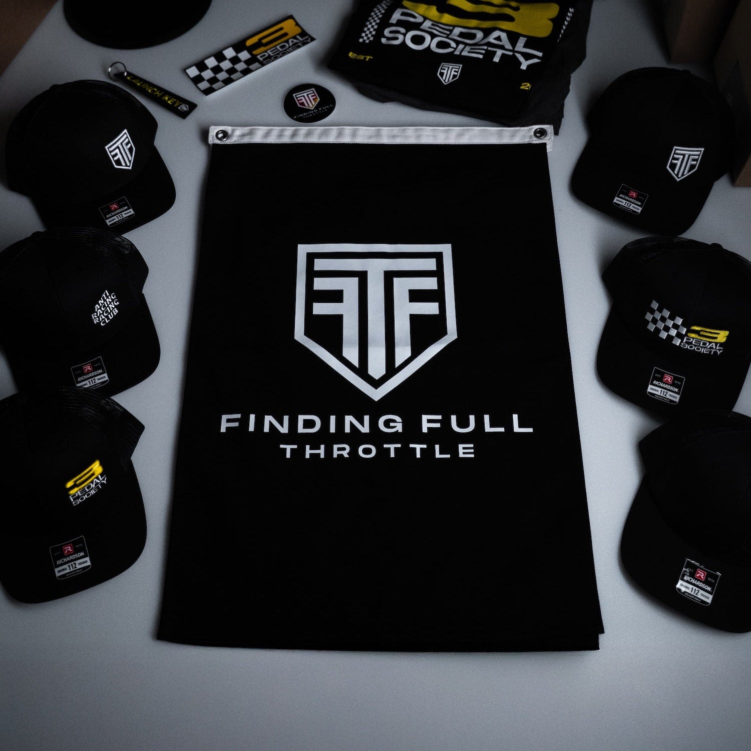 Black merchandise with logos and text on a white surface