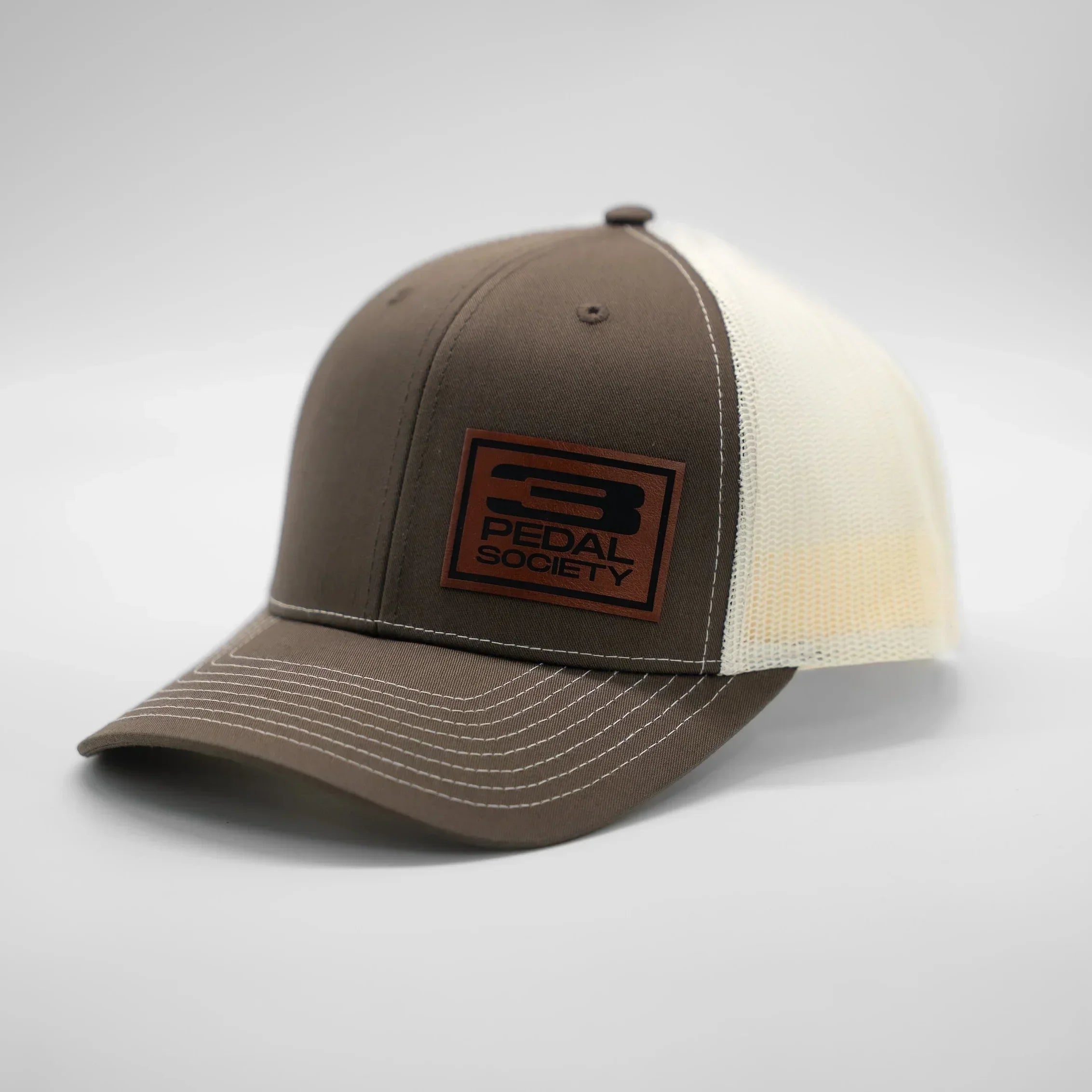 Brown and beige cap with a patch on a gray background