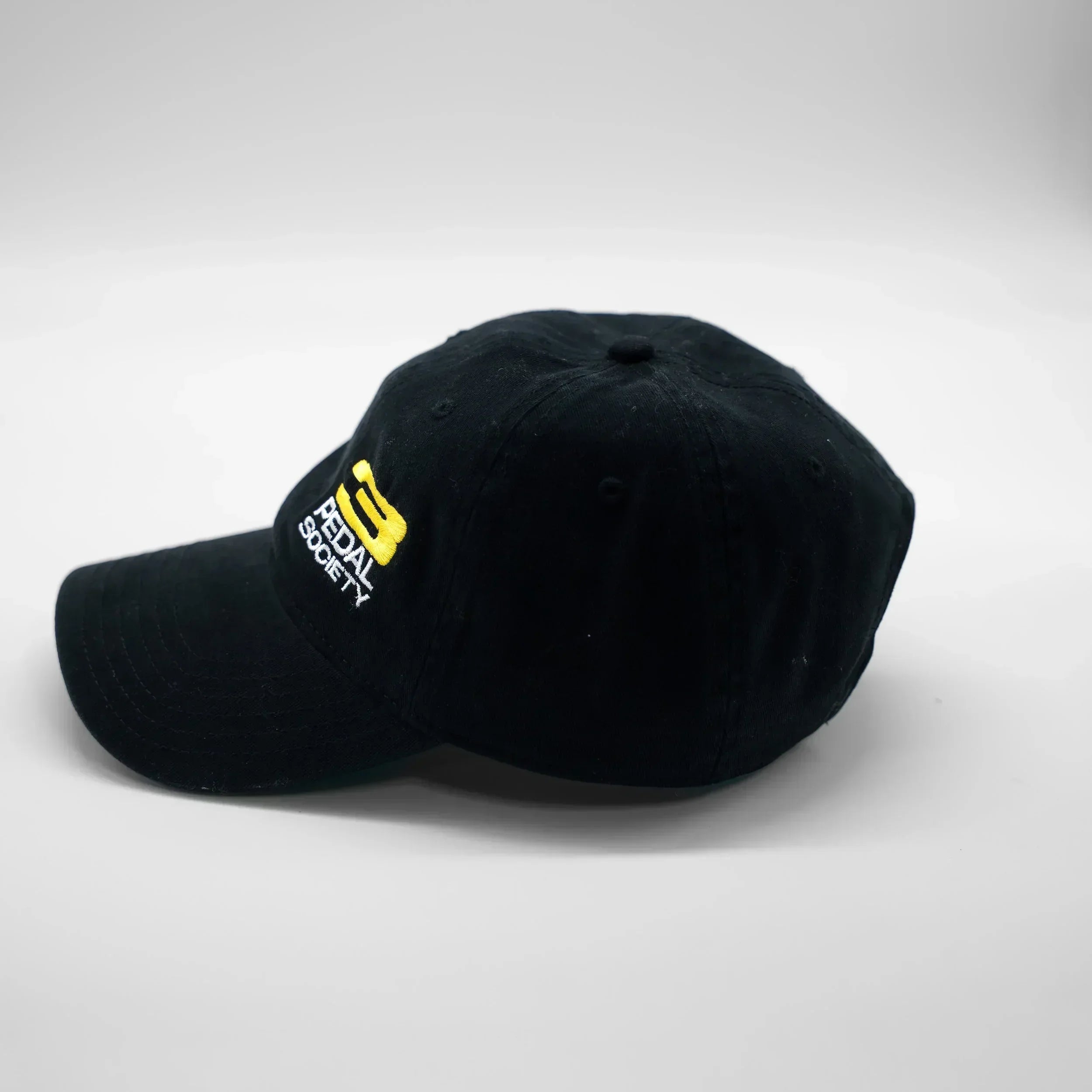 Black cap with a yellow logo on a white background