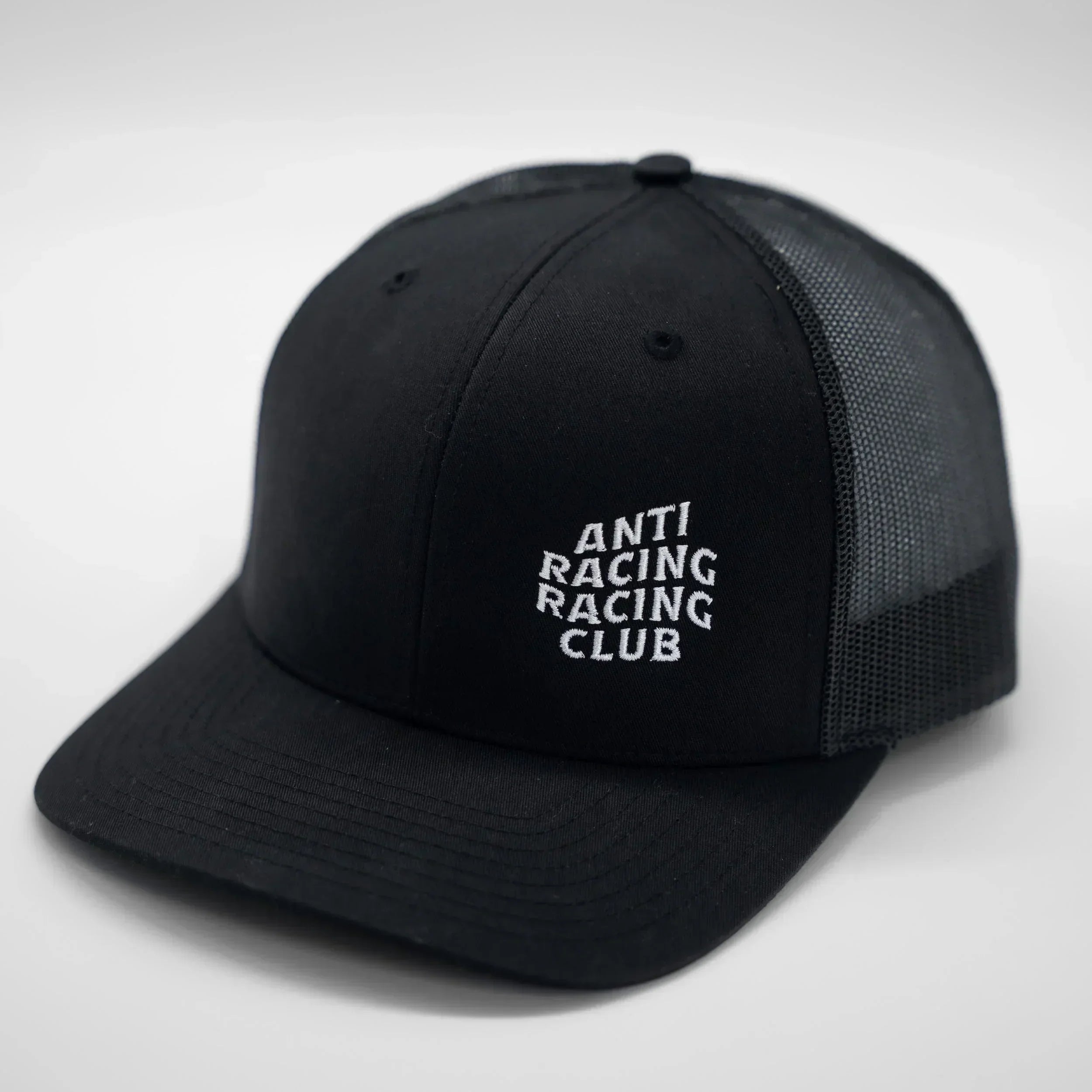 Black cap with 'ANTI RACING RACING CLUB' text on a light gray background