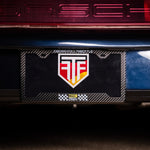 Car license plate with a logo on a dark background