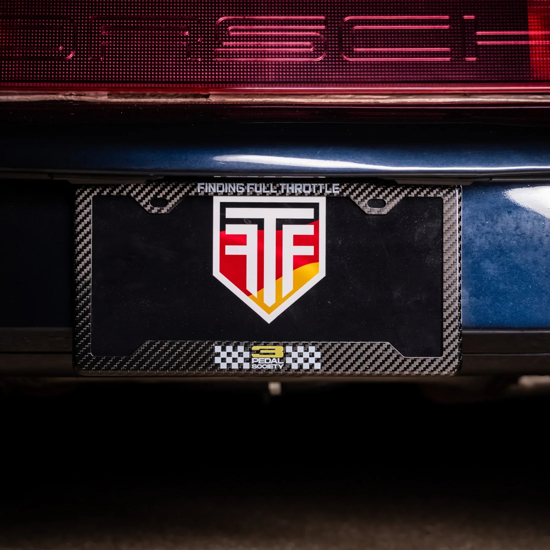 Car license plate with a logo on a dark background