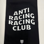 A black rectangular flag with a white hanging sleeve on the left side, featuring the words 'ANTI RACING CLUB' stacked vertically in large white letters and a small white shield logo on the right side.