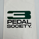 An off-white canvas flag featuring the dark green and black 'Pedal Society' logo, with metal grommets on the left side, shown against a neutral gray background.