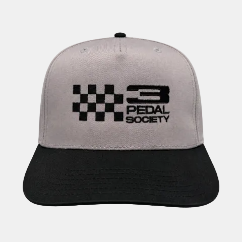 A two-tone snapback cap with a light gray crown and a black curved brim, featuring a black checkered flag and '3 PEDAL SOCIETY' logo embroidered on the front.